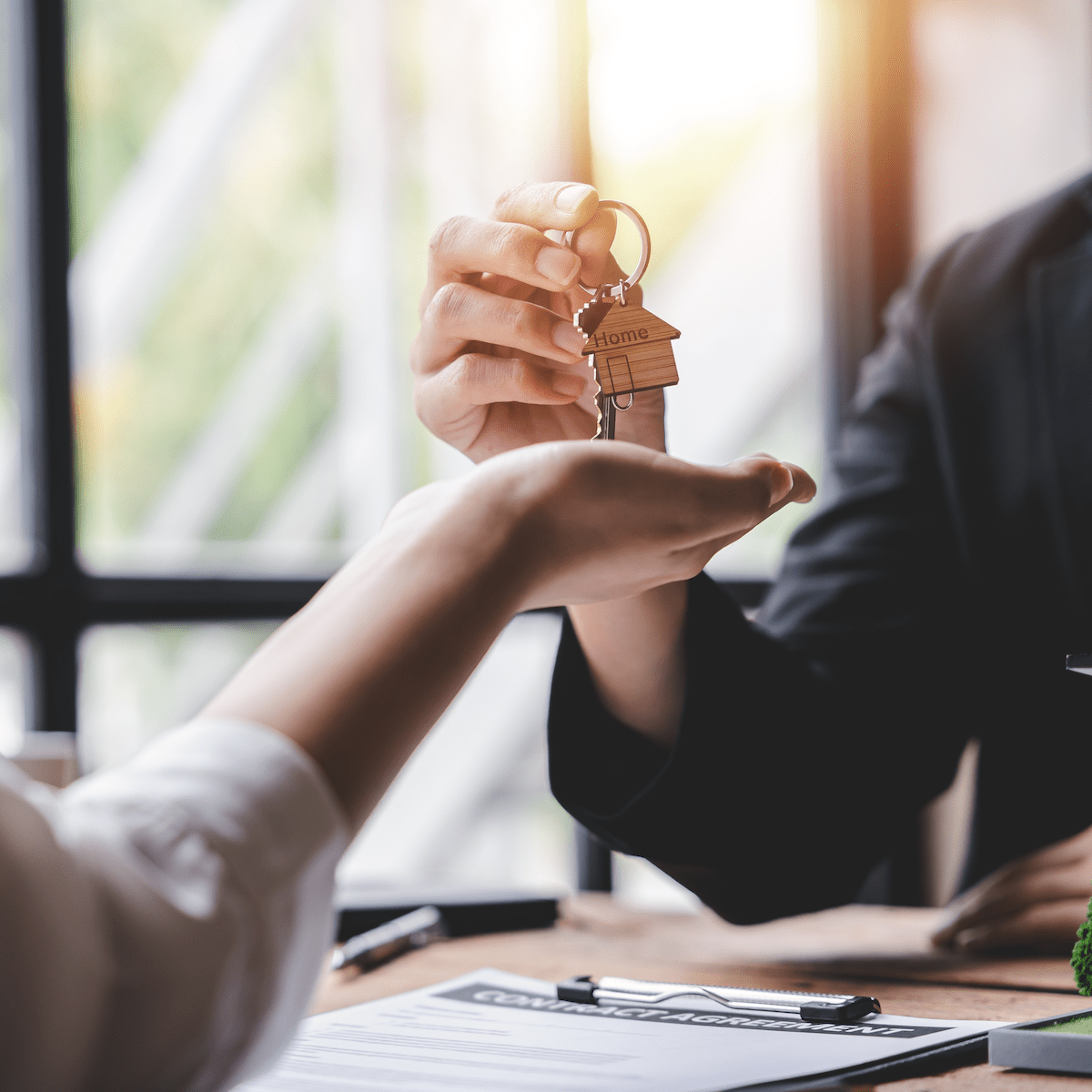 Man passing key to woman for new home.