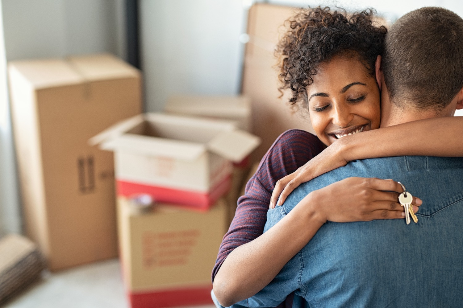 Woman hugging man and holding home keys.