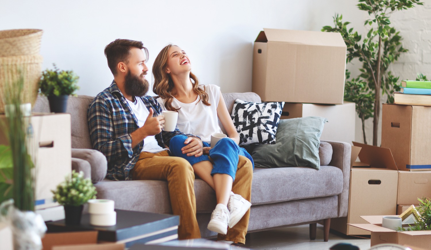 A happy young married couple moves to new apartment.